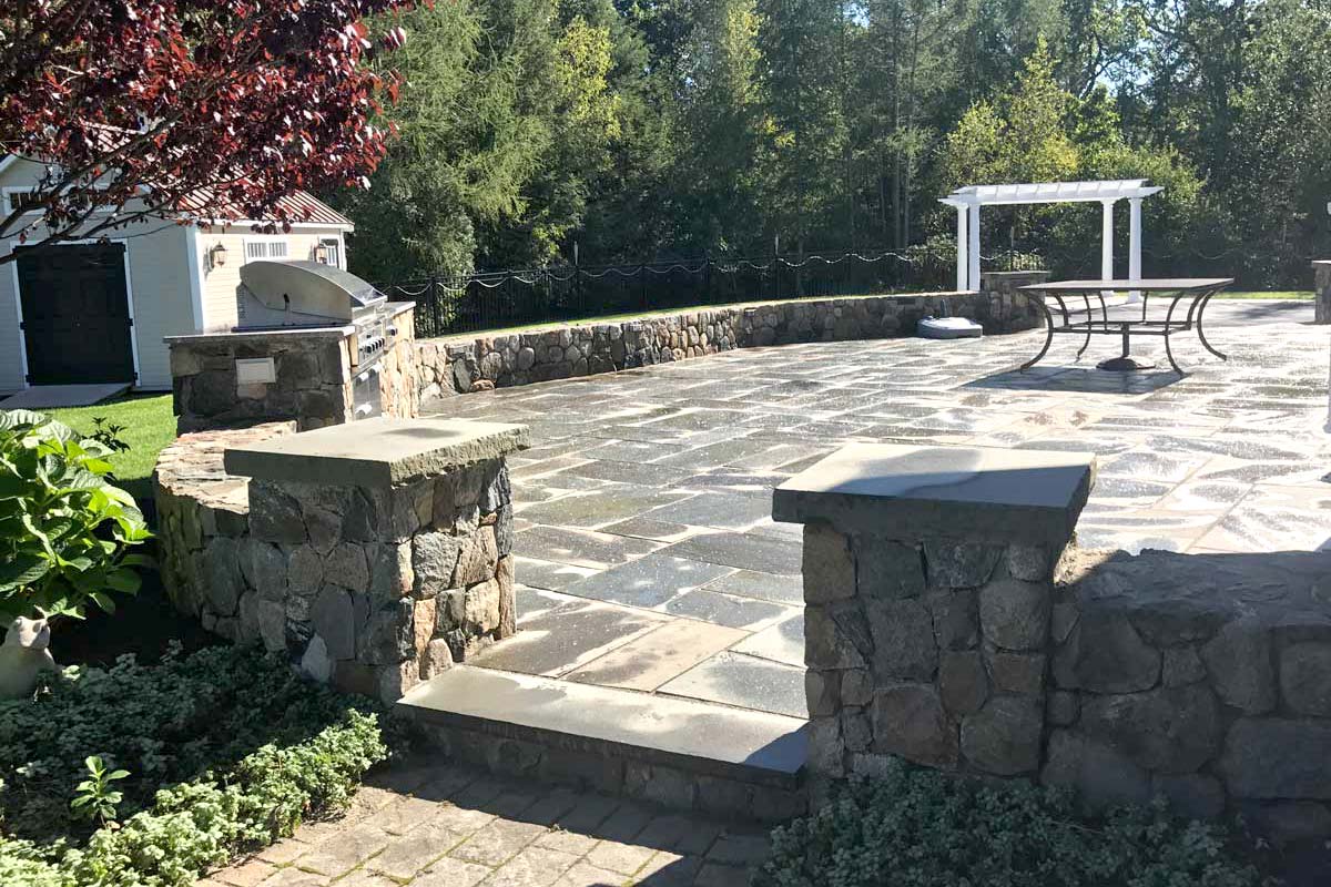 The Natural Landscape Inc. – New England fieldstone walls and outdoor kitchen with bluestone patio