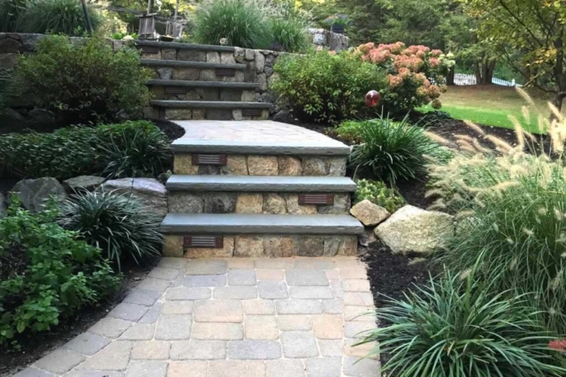 The Natural Landscape Inc. – New England fieldstone wall; thermal bluestone stair treads; concrete paver walkway